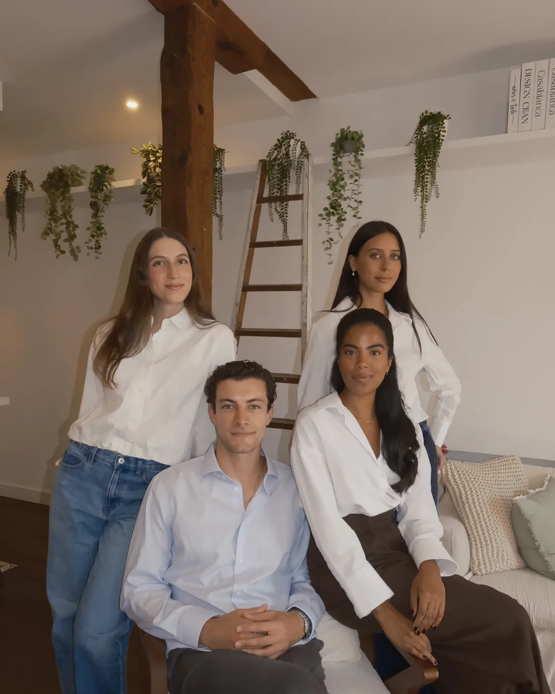 El equipo de WM Property en un salón con vigas de madera y plantas colgantes